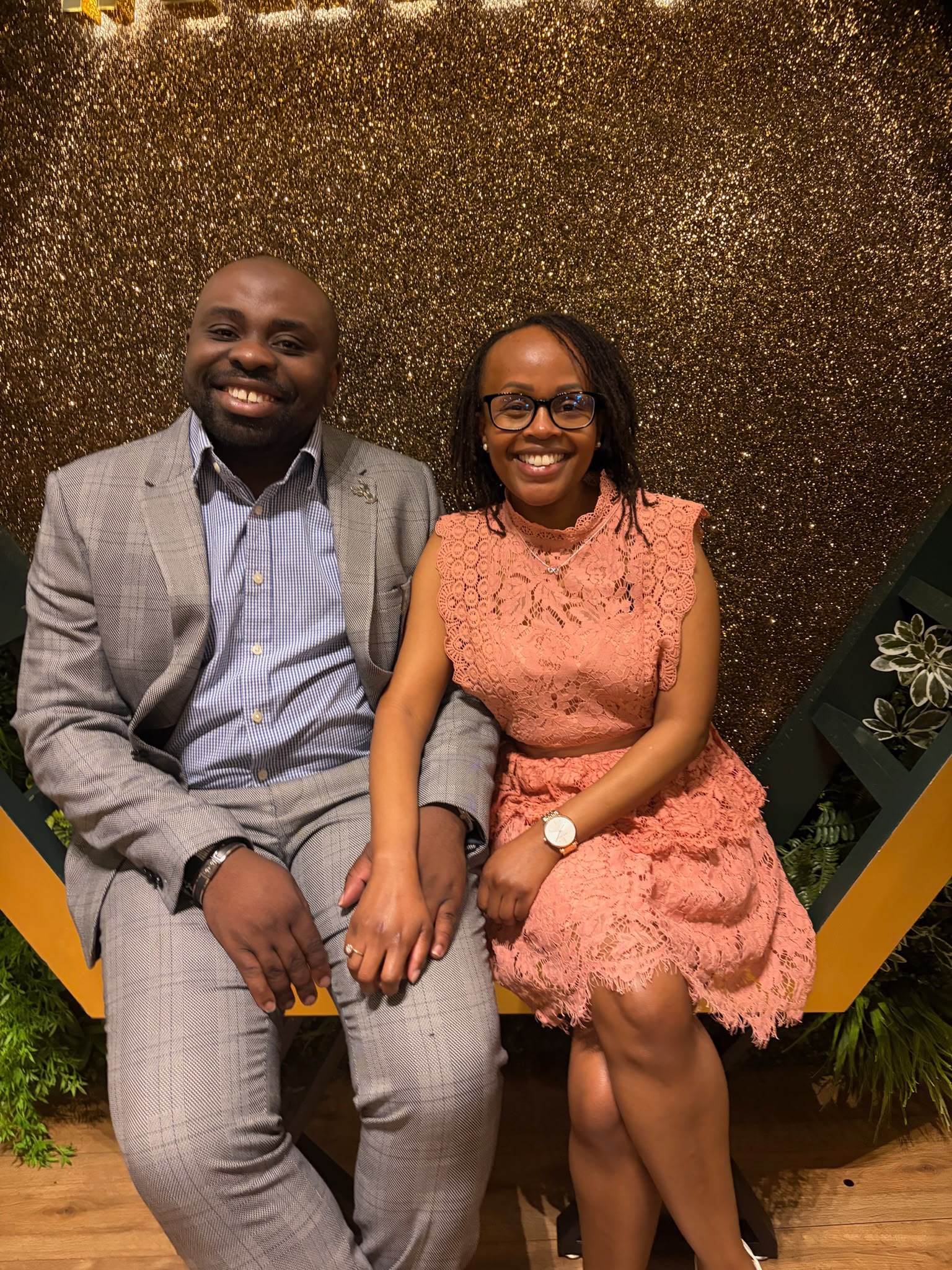 Leo and Njoki, dressed up against a golden backdrop
