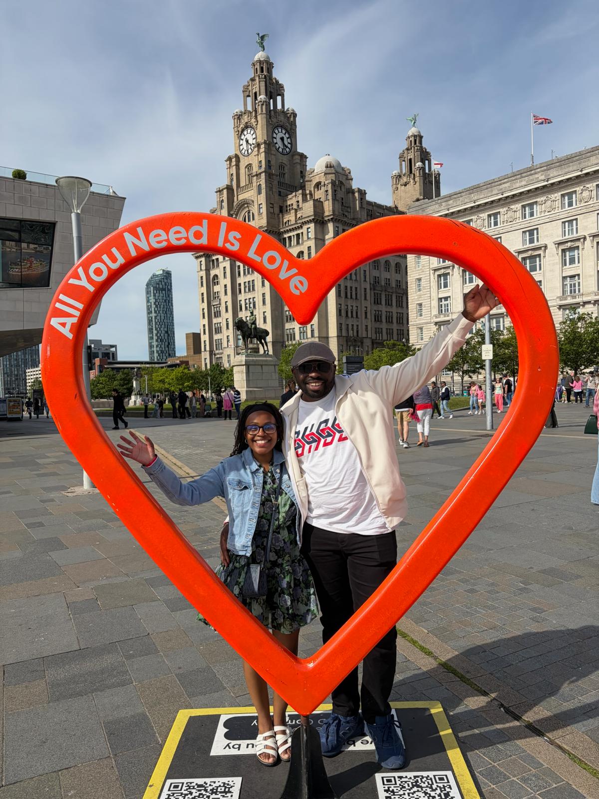 Leo and Njoki inside the &lsquo;All You Need Is Love&rsquo; heart sculpture in Liverpool